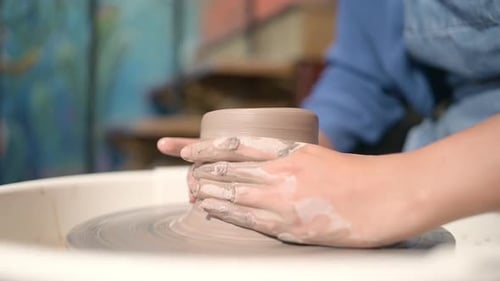 Hands Forming Clay on Pottery Wheel Close Up
