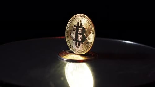 Bitcoin BTC Cryptocurrency Münze, die sich auf einer Spiegeloberfläche dreht