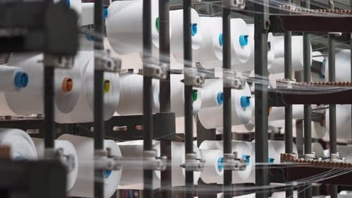 Industrial Machine with White Thread Spools in Action