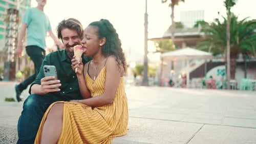 Close up of happy man and smiling woman watching video on smartphone
