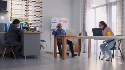 Un directeur chauve célèbre une transaction commerciale réussie avec ses collègues de bureau