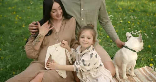 Happy Pregnant Family Enjoys Springtime Picnic with Dog