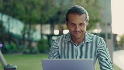 Handsome Guy Working Remotely in the Fresh Air at the Park Using a Laptop