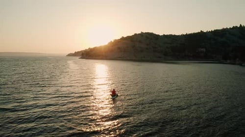 Woman Paddleboarding on Sea Bay at Sunrise