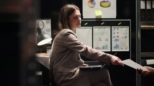 Man and woman discuss documents in office