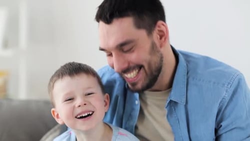 Happy Father and Child Smiling at Camera Indoors