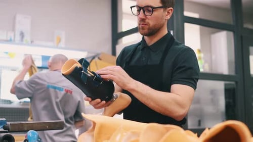 Trägt schwarzes Material. Techniker, der im modernen Labor mit Prothesen arbeitet