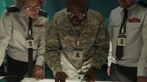 Adults Review Military Strategy in a Dark Room