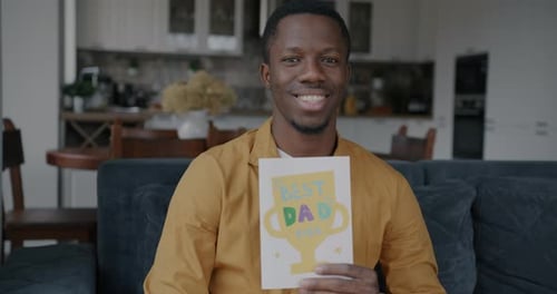 Smiling Man Holding a Birthday Greeting Card