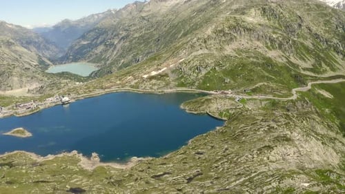 Aerial drone footage of lake on Grimselpass in Switerland, slowly turning to the right, revealing a