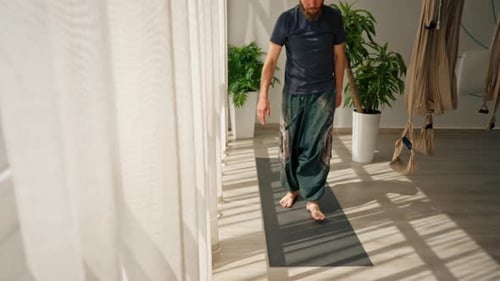 Man Practices Yoga in Bright Studio Setting