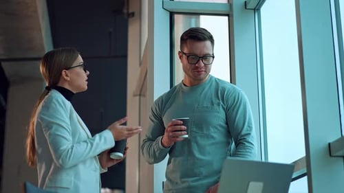 Business Colleagues Talk Over Laptop With Coffee