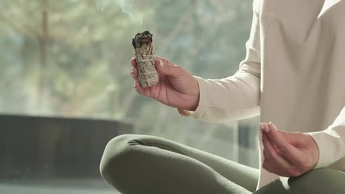 Woman meditates with incense