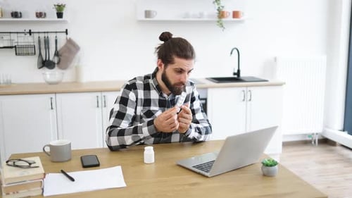 Unhealthy Male in Shirt Coughing Into Fist While Sitting at Desk with Computer