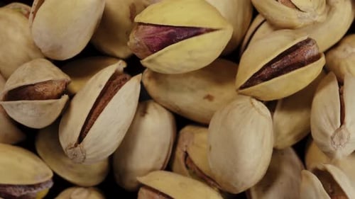 Salted pistachios in shell. Rotates in motion. A scattering of pistachios. Close-up. View from above