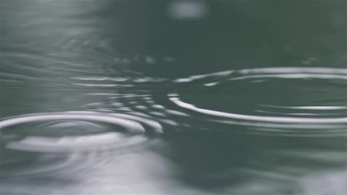 Regentropfen fallen in den Wasserpool
