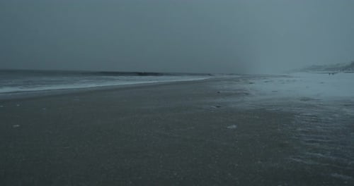 Wind blows the snow over the beach on a snowy day on Sylt