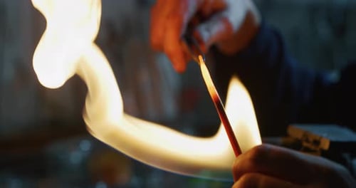 Zeitlupe eines erfahrenen Glasbläsers, der mit Flammen an einem handgefertigten Kunststück aus Glas von pr arbeitet