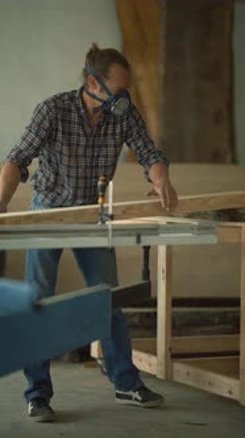 Carpenter with Respirator Mask Handling Wood Plank
