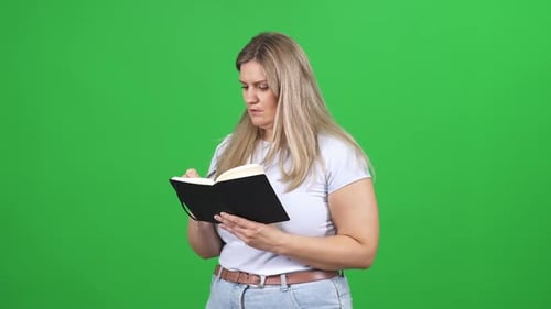 Blond Woman Writing in Journal on Green Screen
