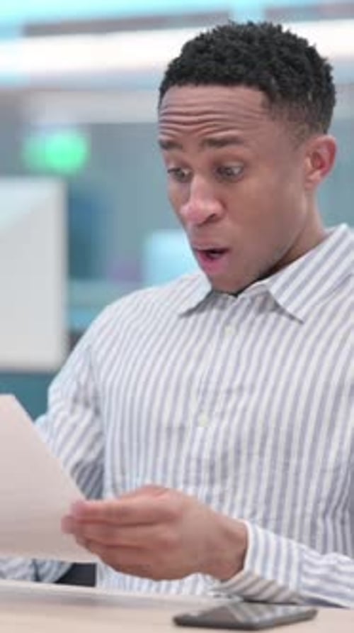 Young Man Reacts to Bad News in Document