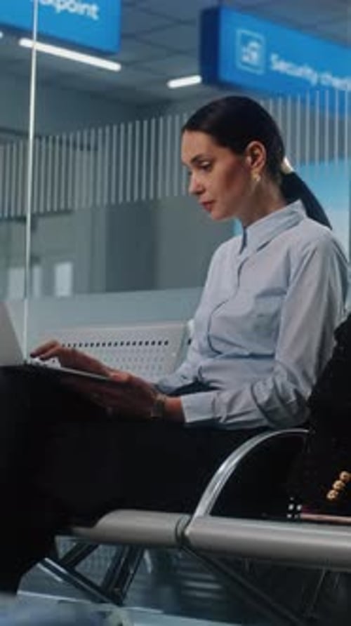 Successful Businesswoman Using Laptop Computer Waiting for Flight in Departure Lounge