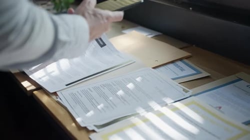 Un espion ou un agent secret examine les documents classifiés disséminés sur le bureau et prend des photos discrètement