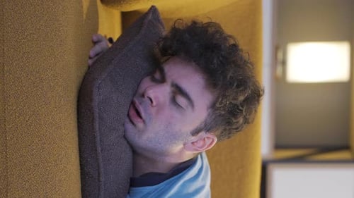 Vertical video of Man sleeping at home.