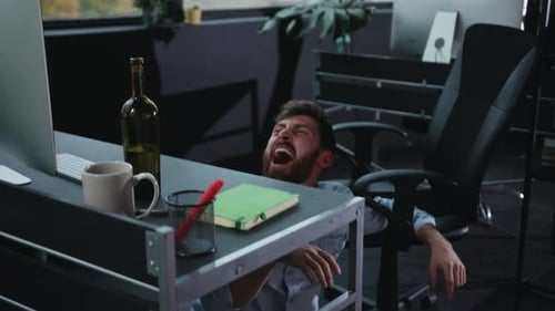 A Man Has Tragically Fallen Onto the Floor Beneath His Desk Appearing in Great Distress