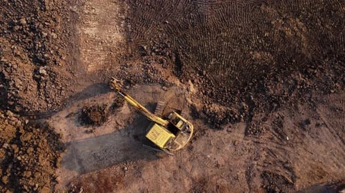 Excavator dig ground at construction site. Aerial view of a wheel loader excavator with a backhoe