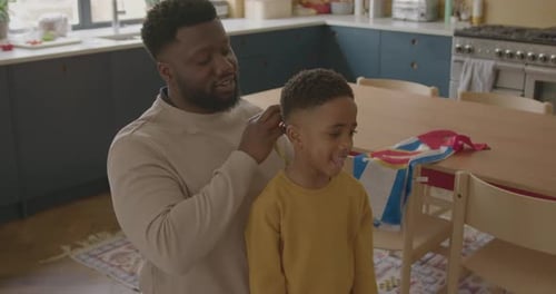 Father Helps Son Put On Superhero Mask