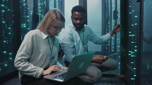 Data Center Technicians Working on Servers with Laptop