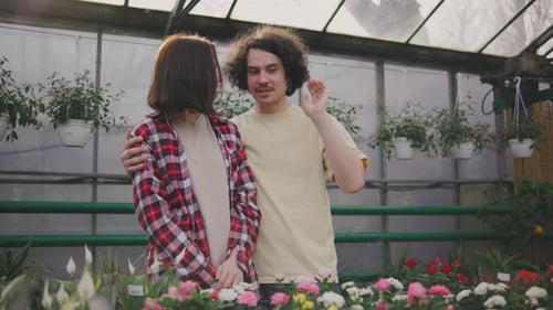 Ein Paar wählt eine schöne Pflanze für ihr Zuhause Schönes junges Paar Mann und Frau wählen eine