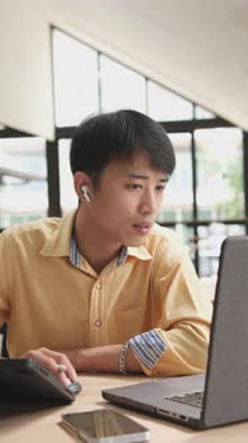 Young Adult Working at Desk Using Laptop