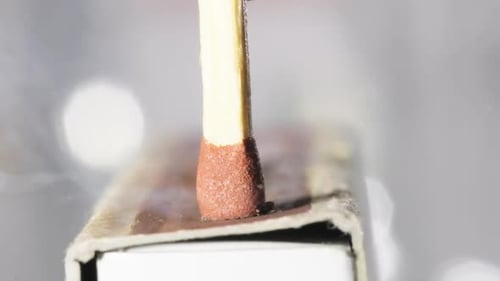 Makroaufnahme von Streichholz auf einer Streichholzschachtel, die sich tagsüber entzündet, Zeitlupenaufnahme