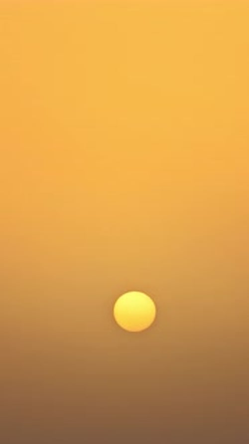 Minimal Winter Sun Rising Through Warm Orange Sky