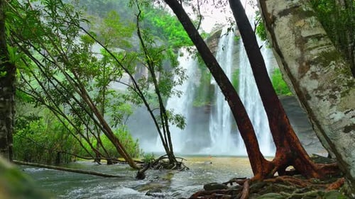 Majestic waterfall cascades from towering cliff.