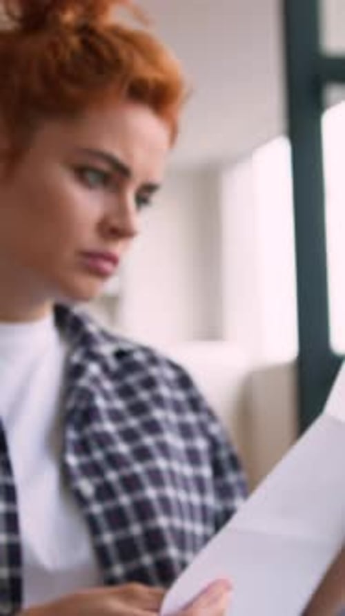 Woman Looks Shocked Reading a Letter Indoors
