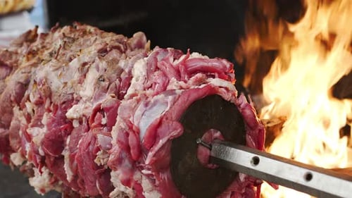 Raw Meat Revolving Over Open Fire