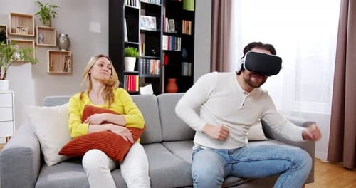 Woman Watches Man Play Virtual Reality at Home