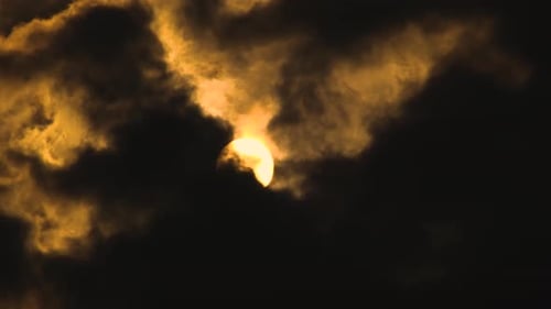 Große glühende Sonne geht durch dunkle Wolken am Himmel auf. Sonnenaufgang. Sonne scheint bei düsterem Wetter
nach s
