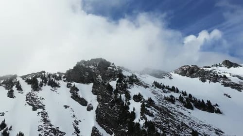 Clouds Engulf Snowy Mountain Peaks. British Columbia, Canada.