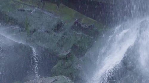 Cascada que fluye a través de piedras cubiertas de musgo en cámara lenta