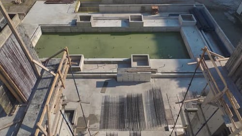 Vista aérea: construcción de rascacielos en progreso: trabajadores y grúas en acción