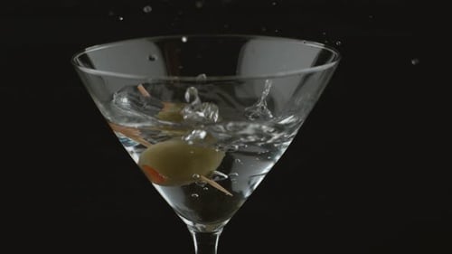 Olive Falling into Martini Glass with Clear Liquid