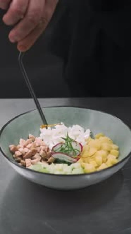 Chef Preparing Fresh Salad in Bowl
