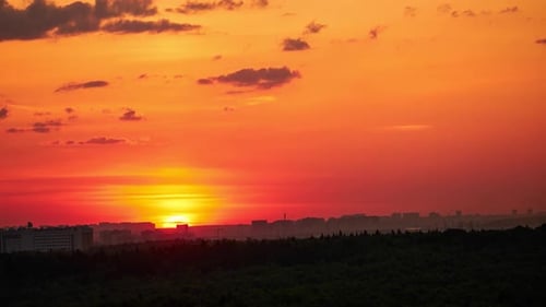 The morning sun rising above the horizon, the landscape at dawn. Summer sunrise, timelapse