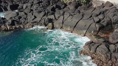 Aerial Drone View of Turquoise Ocean Water Crashing Against Volcanic Rocks