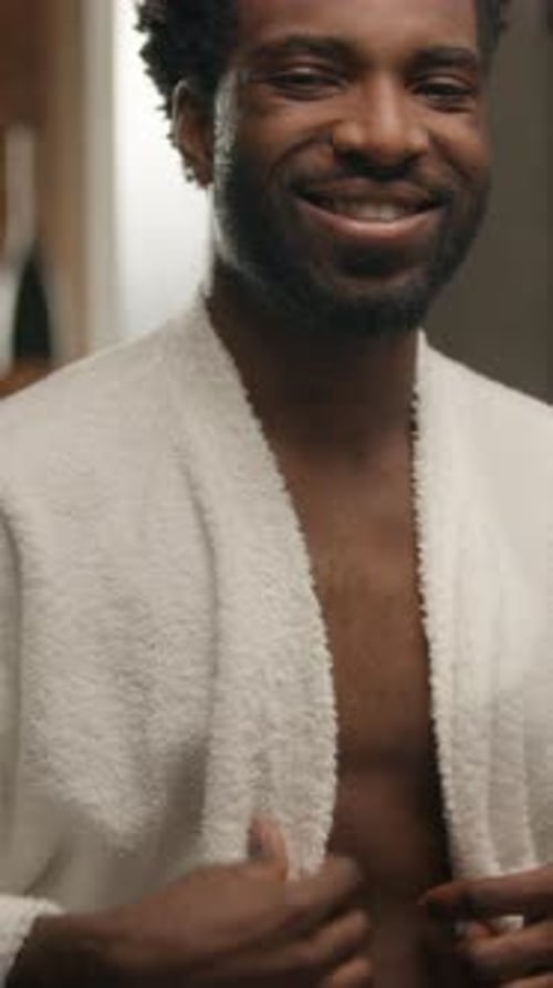 African American Man Wearing Bathrobe Shower Naked Male in Bathroom Hotel Spa Procedure Looking at