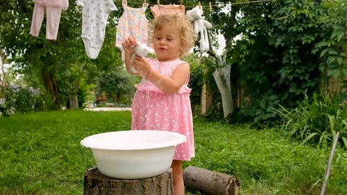 The Child is Washing Clothes in the Garden Selective Focus